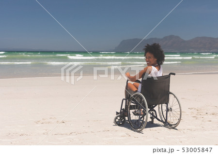 Young woman disable sitting on wheelchair at beach Young woman disable sitting on wheelchair at beach 53005847
