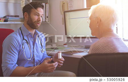 Male doctor and senior woman interacting with each other in clinic Male doctor and senior woman interacting with each other in clinic 53005926