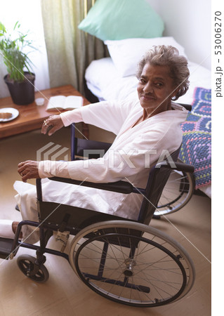 Happy senior woman sitting in wheelchair at nursing home 53006270