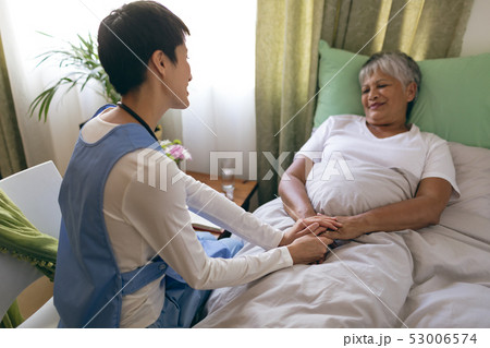 Female nurse taking care of senior female patient at retirement home 53006574