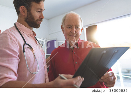 Male doctor showing medical report to a senior patient 53006685
