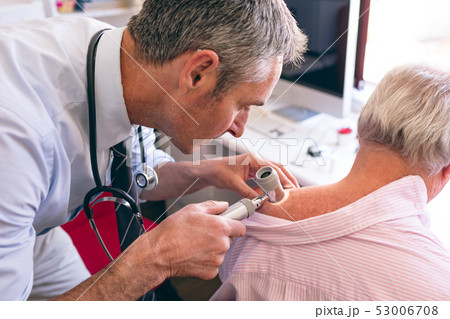 Male dermatologist examining senior patient with dermatoscopy Male dermatologist examining senior patient with dermatoscopy 53006708