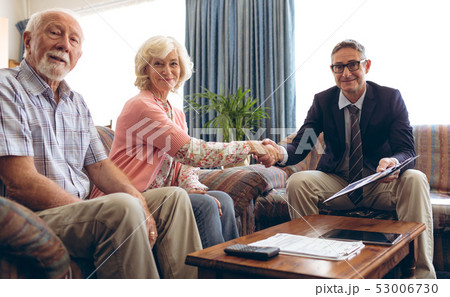 Matured male physician shaking hand and smiling at retirement home Matured male physician shaking hand and smiling at retirement home 53006730