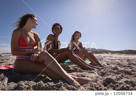 Happy beautiful young women relaxing on beach in the sunshine Happy beautiful young women relaxing on beach in the sunshine 53006738