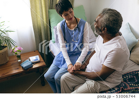 Female doctor and senior male patient interacting with each other 53006744