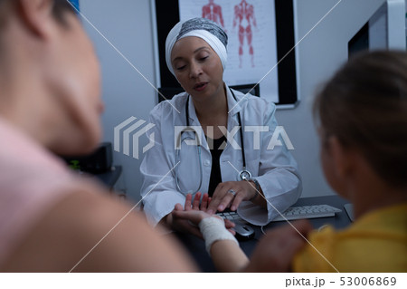 Matured female doctor examining girl hand in clinic 53006869