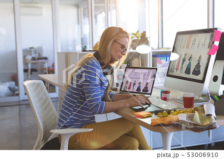 Female fashion designer using graphic tablet at desk Female fashion designer using graphic tablet at desk 53006910