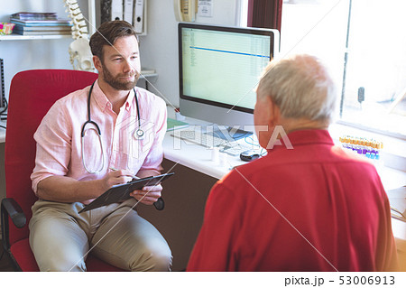 Male doctor talking to senior patient while holding medical report Male doctor talking to senior patient while holding medical report 53006913