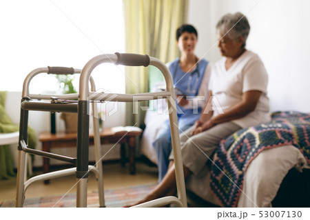 Female doctor interacting with senior female patient at retirement home Female doctor interacting with senior female patient at retirement home 53007130