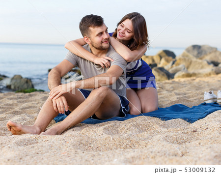Happy loving couple sitting and hugging Happy loving couple sitting and hugging 53009132