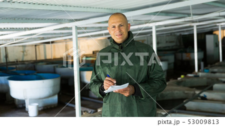 Man at trout breeding incubator Man at trout breeding incubator 53009813