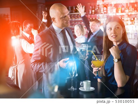 Man talking to woman on corporate party Man talking to woman on corporate party 53010055