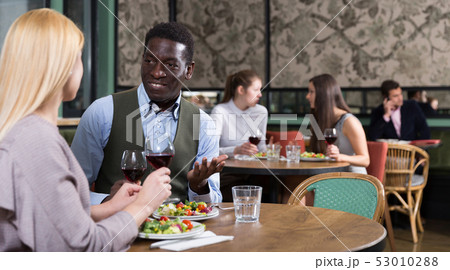 African American businessman with female partner in restaurant African American businessman with female partner in restaurant 53010288