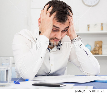 Man struggling to pay bills Man struggling to pay bills 53010373