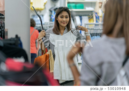 Happy Asian woman choosing clothes with reflection of glass in store shop with happy action at department center 53010948