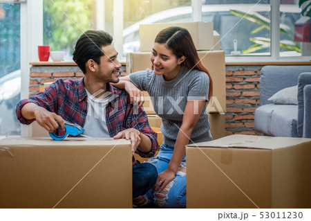Asian young couple packing the big cardboard box for moving in new house, Moving and House Hunting concept, 53011230