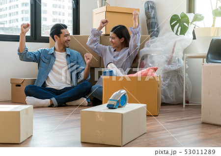 Asian young couple are glad after successfull packing the big cardboard box for moving in new house, Moving and House Hunting concept, 53011289