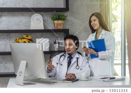 Couple of Asian doctors working with colleague which using technology computer in modern office of hospital, physician concept Couple of Asian doctors working with colleague which using technology computer in modern office of hospital, physician concept 53011333