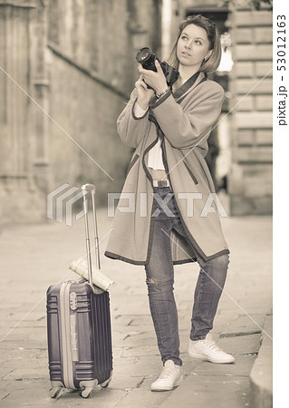 Young woman looking curious and taking pictures 53012163