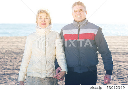 middle-aged husband and wife spend time together happily at sea beach 53012349