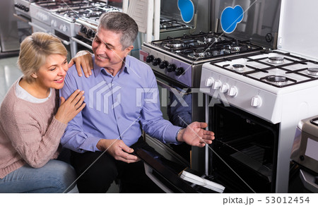 Adults are buying in center of household appliances the plate Adults are buying in center of household appliances the plate 53012454