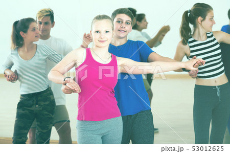Group of teen dancing salsa in dance studio Group of teen dancing salsa in dance studio 53012625