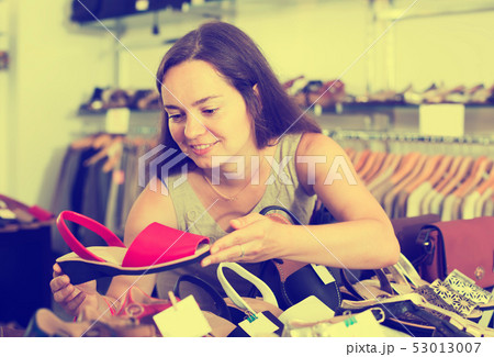 charming female customer selecting shoes in footgear center 53013007