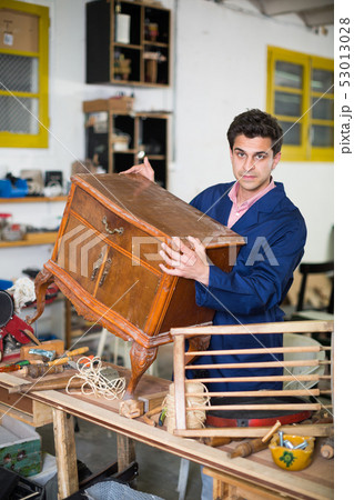 Restorer of furniture in workroom 53013028