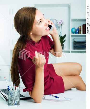 Woman sitting on working table 53013449