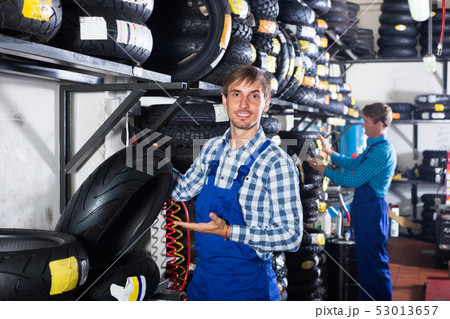 worker holding new tyre worker holding new tyre 53013657