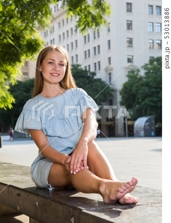 Girl with long hair sitting on parapet Girl with long hair sitting on parapet 53013886