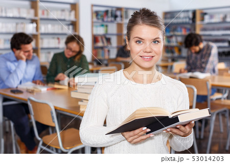 female student browsing textbooks in university library female student browsing textbooks in university library 53014203