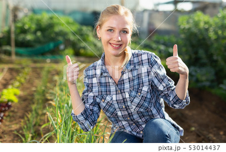 Girl in working wear at her garden 53014437
