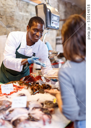 Salesman serving customer raw fish Salesman serving customer raw fish 53014658