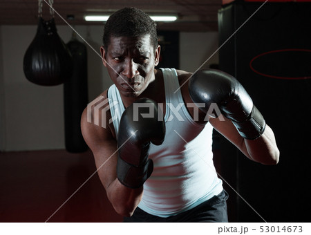 Confident afro american boxer holds training in the ring 53014673