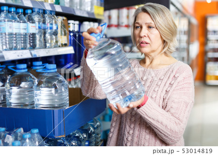 Portrait of nice woman choosing bottled water Portrait of nice woman choosing bottled water 53014819