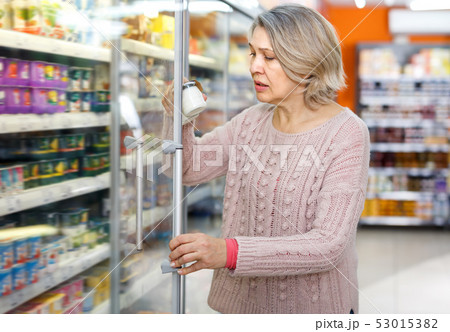 Amazed female reading contents of products 53015382