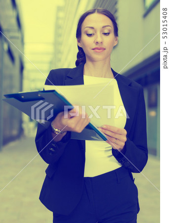 Woman is examining documents 53015408