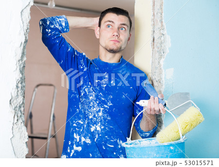 Perplexed worker inspecting room Perplexed worker inspecting room 53015571