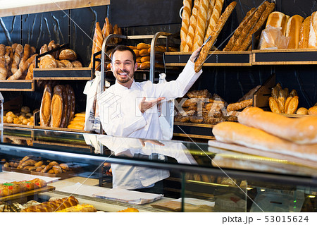Seller offering fresh loaf of bread Seller offering fresh loaf of bread 53015624
