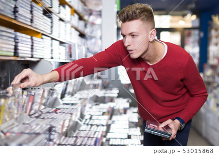 Positive surprised man in search of movies Positive surprised man in search of movies 53015868