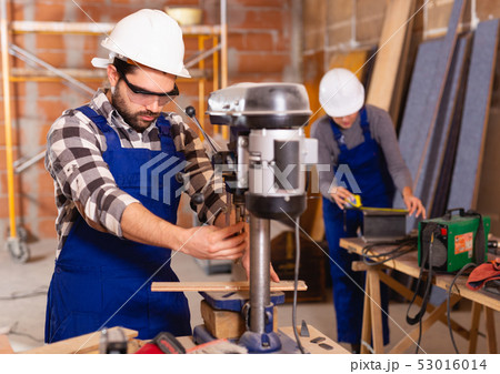Man is worker behind drilling machine 53016014