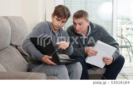 Guy with his father are resting and looking in notebook Guy with his father are resting and looking in notebook 53016164
