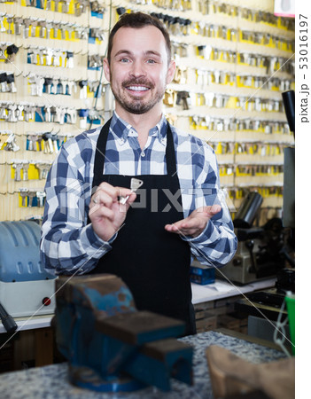 Young man worker showing result of his key making 53016197