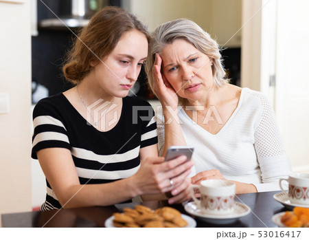 Upset women using smartphone 53016417