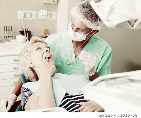 Dentist performing treatment to woman Dentist performing treatment to woman 53016738