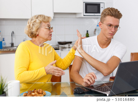 Mother lecturing her sad adult son 53016880