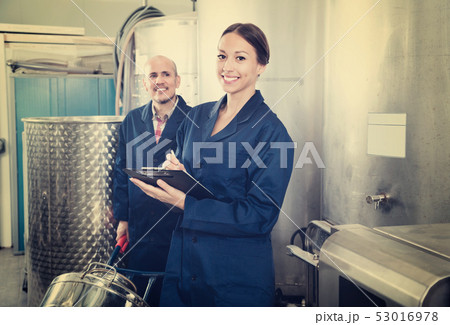 Woman holding cardboard and standing with man working 53016978
