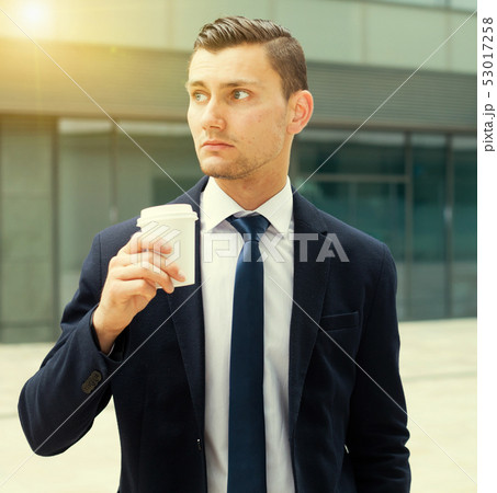 Businessman is drinking coffee outdoors Businessman is drinking coffee outdoors 53017258