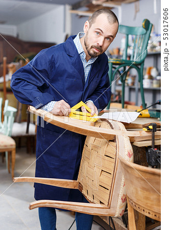 Carpenter repairing antique chair 53017606